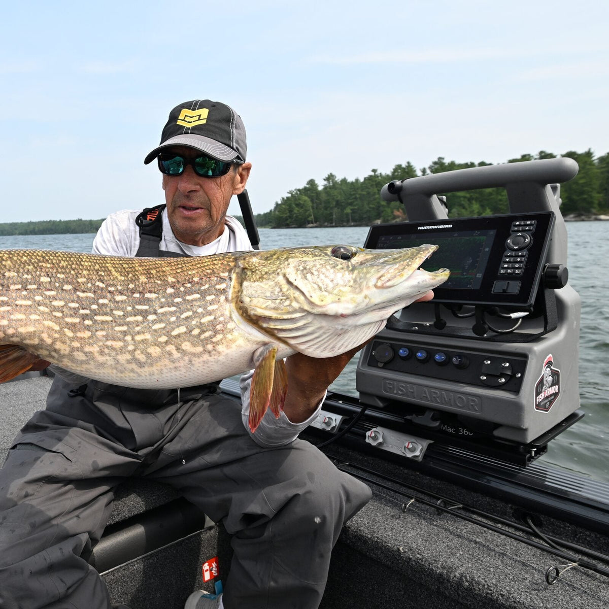 Northern pike held up next to a boat-mounted Fish Armor shuttle